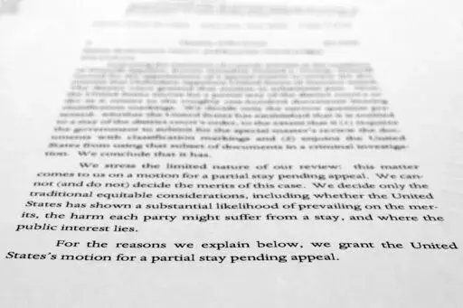 A page from a U.S. Court of Appeals for the 11th Circuit in Atlanta ruling that lifts a judge's hold on the Justice Department's ability to use classified documents seized by the FBI at Trump's Mar-a-Lago estate, is photographed Wednesday, Sept. 21, 2022. The ruling clears the way for the department to immediately resume its use of the documents in its investigation.(AP Photo/Jon Elswick)