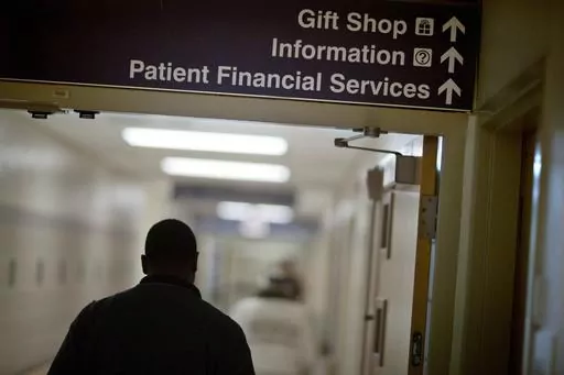 A sign points visitors toward the financial services department at a hospital, Friday, Jan. 24, 2014. Medicaid coverage will end for millions of Americans in 2023, and that pushes many into unfamiliar territory: the health insurance marketplace. (AP Photo/David Goldman, File)