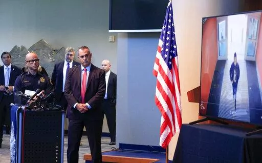 Dallas police Chief Eddie García, left, and FBI Dallas Special Agent in Charge Matthew DeSarno watch surveillance footage of alleged shooter Portia Odufuwa enter Dallas Love Field airport during a press conference, Tuesday, July 26, 2022, at Jack Evans Police Headquarters in Dallas. Odufuwa, accused of firing several gunshots inside the airport faces a charge of aggravated assault of a public servant because she allegedly fired one round toward a police officer, according to an arrest warrant. 